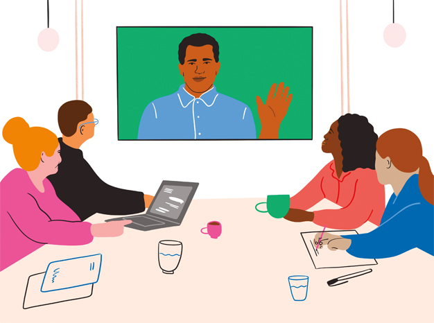 People in a boardroom speaking with a colleague on a video chat
