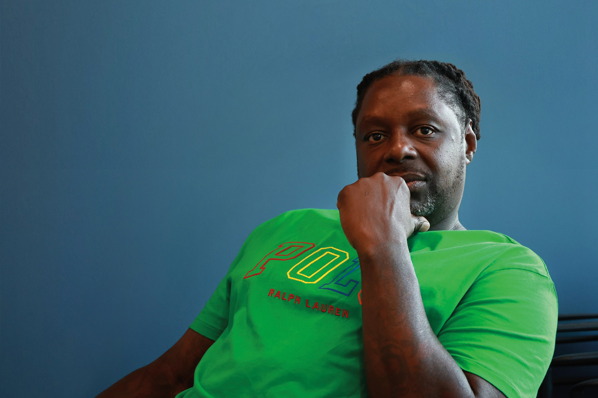 Photo of man in green shirt against a blue background