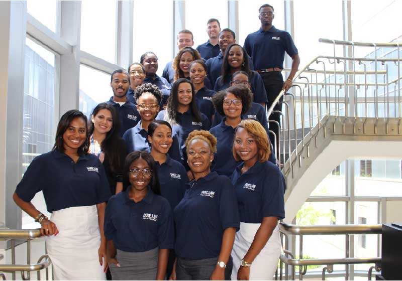 Photo of student group posing in stairwell in blue shirts